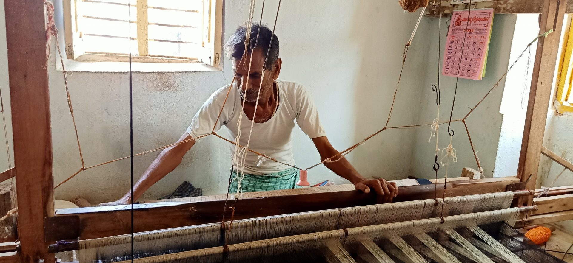 A weaver working khadi cloth on a handloom